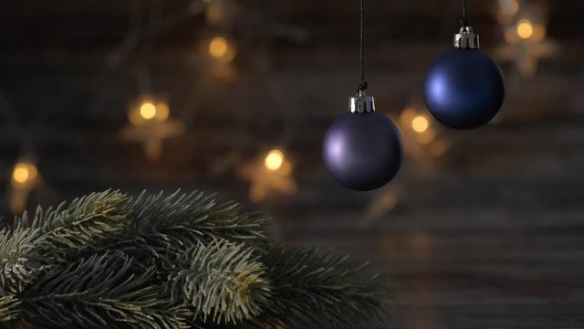 Two blue Christmas ball and spruce branches on the background of beautiful bokeh.