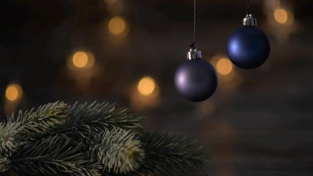 Two blue Christmas ball and spruce branches on the background of beautiful bokeh.