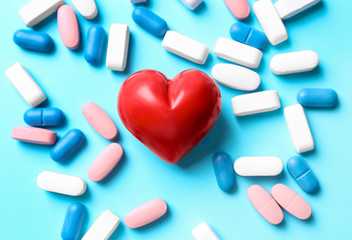 Red heart with pills on table