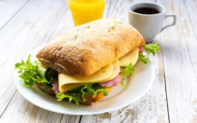 Chiabatta sandwich, cup of coffee and orange juice