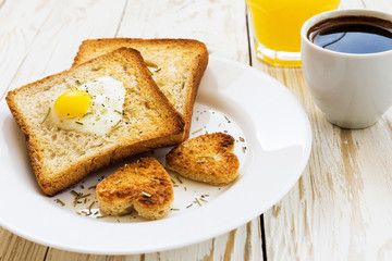 Egg fried in a heart-shaped toast cutout sprinkled