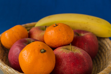 Mandarin Apples and Bananas on blue background
