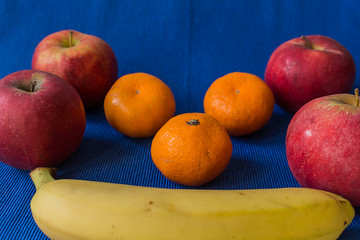 Mandarin Apples and Bananas on blue background