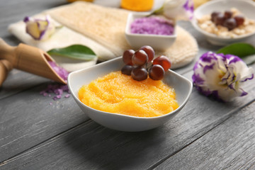 Small bowl with scrub and set for peeling on background, closeup