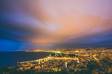 Nightview of the city of Nice, France. The view goes from the foreground with the castle of Nice to the airport in the background.