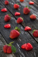 Strawberries and candy on wooden table