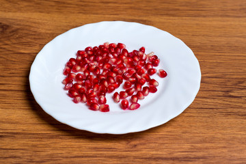 Pomegranate slices and garnet fruit seeds on table. Pomegranate whole. Useful fruit.