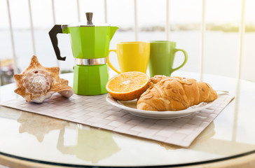 Breakfast with coffee on hotel's balcony, fresh croissants and s