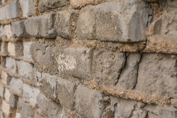 Old brick wall with destroyed in shades of gray side view close up
