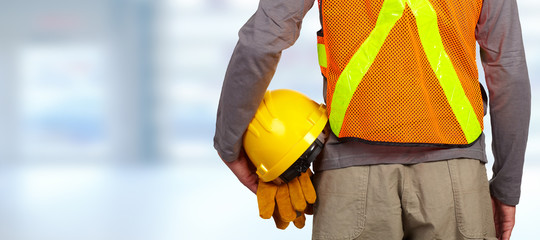 Worker with helmet in orange security vest.