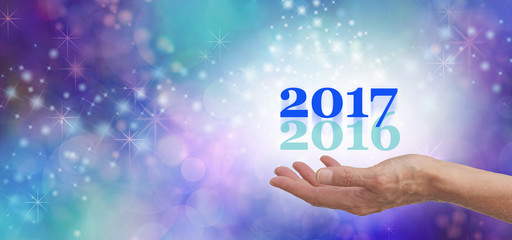 Leave 2016 behind for 2017 - female hand open palm outstretched with a pale green 2016 and a cobalt...