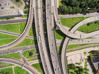 Aerial view at junctions of city highway. Vehicles drive on roads. Russia