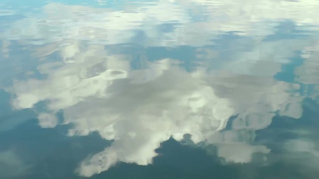 blue sky with clouds reflection in calm water