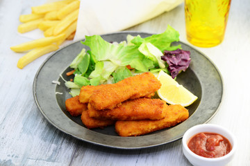 Fischstäbchen mit Salat und Pommes