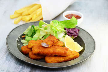 Fischstäbchen mit Salat und Pommes