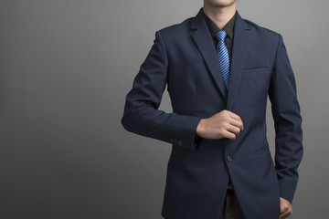 Close up of businessman in blue suit confident on gray backgroun