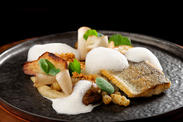 Fine dining Seabass fillets with baked potato and spices