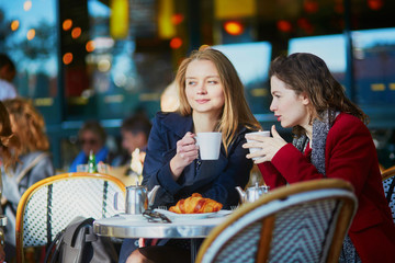Two young girls in Parisian outdoor cafe