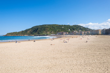 Surfer do water sport, people relax at the beach La Zurriola in Donostia San Sebastian. The beach is situated at the district Gros of San Sebastian. The beach is famous for surfing,sports and relaxing