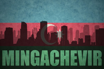 Fototapeta na wymiar abstract silhouette of the city with text Mingachevir at the vintage azerbaijan flag
