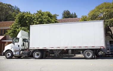 Side view of delivery truck parked on city street. Horizontal.