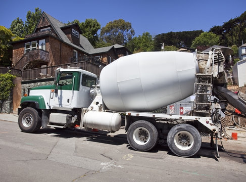 Cement truck parked on grade at construction site on residential street. Horizontal.