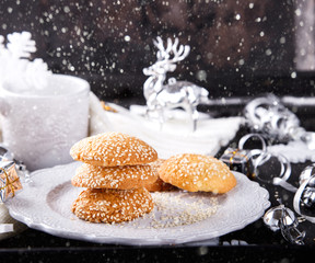 Christmas Cookies with milk  and sesame seedson on a Black Background decorated with a Festive Decoration.Advent.Cakes.selective focus.