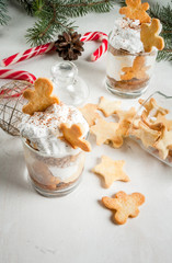 Fototapeta na wymiar Christmas dessert, funny food for children or party. Ginger Trifle with gingerbread in form of men, diving in the drifts of whipped cream. Copy space