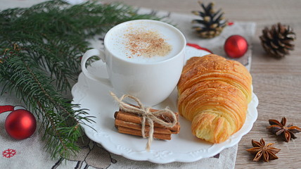 Cup of cappuccino with christmas decorations on wooden table