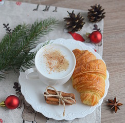 Cup of cappuccino with christmas decorations on wooden table