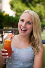 young woman drinks cocktail outdoor on a hot summer afternoon in