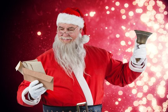 Composite image of santa claus reading envelope with bell