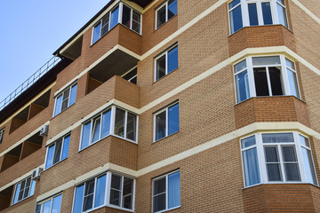 Balconies and windows of a multi-storey new house. New house of brick