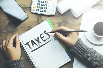 woman writing taxes on notebook