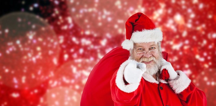 Composite image of close-up portrait of santa claus pointing whi
