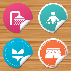 Round stickers or website banners. Swimming pool icons. Shower water drops and swimwear symbols. Human stands in sea waves sign. Trunks and women underwear. Circle badges with bended corner. Vector