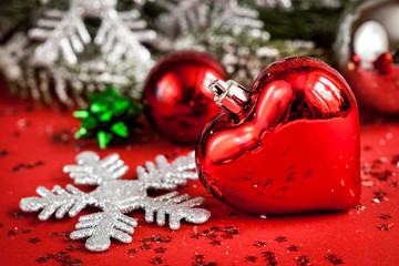 Christmas toys and spruce branches on red background close up