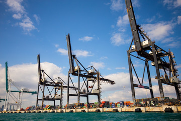 Fototapeta premium Port Miami. Various ships loading onto the port with the help of a crane in the port of Miami