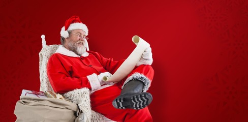 Composite image of santa claus reading wish list on scroll again