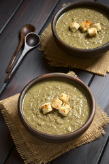 Linsencremesuppe mit Croutons, fotografiert auf dunklem Holz mit natürlichem Licht (Selektiver Fokus, Fokus auf die vorderen Croutons auf der ersten Suppe)