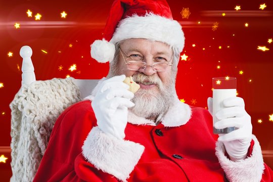 Composite Image Of Santa Claus Holding Glass Of Milk And Cookie