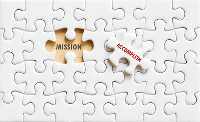 Mission and accomplish words on jigsaw puzzle background
