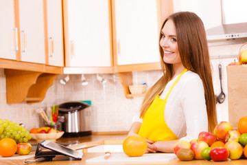 Woman housewife in kitchen using tablet