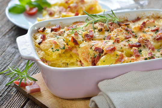Kartoffelgratin mit Parmesan, Sahne und S&uuml;dtiroler Speck frisch aus dem Ofen -  Potato gratin with parmesan cheese, cream and cured bacon from South Tyrol