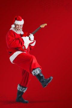 Composite image of cheerful santa claus playing guitar