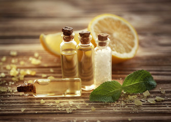 Beautiful spa composition with lemon essential oil on wooden background, closeup