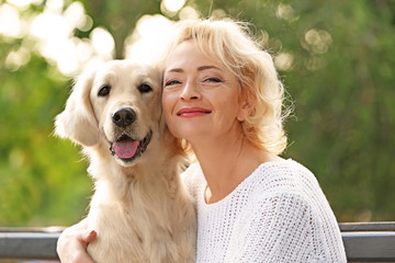 Senior woman sitting on bench with dog, closeup