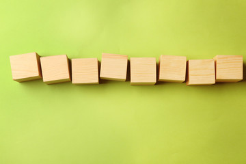 Empty wooden cubes on color background