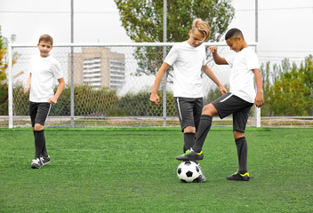Boys playing football at stadium