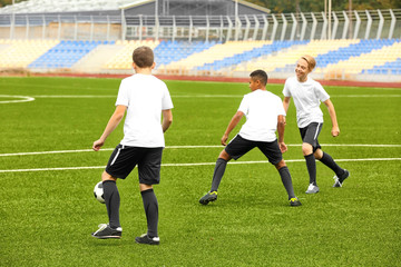 Boys playing football at stadium